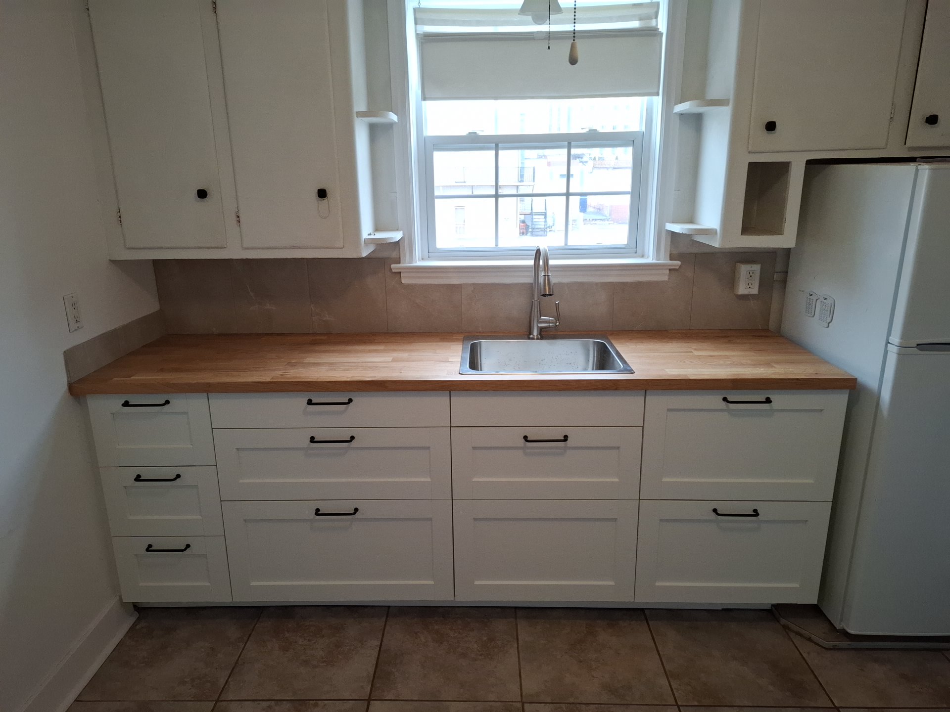 Renovated kitchen with bright cabinetry, new finishes, and warm wood details
