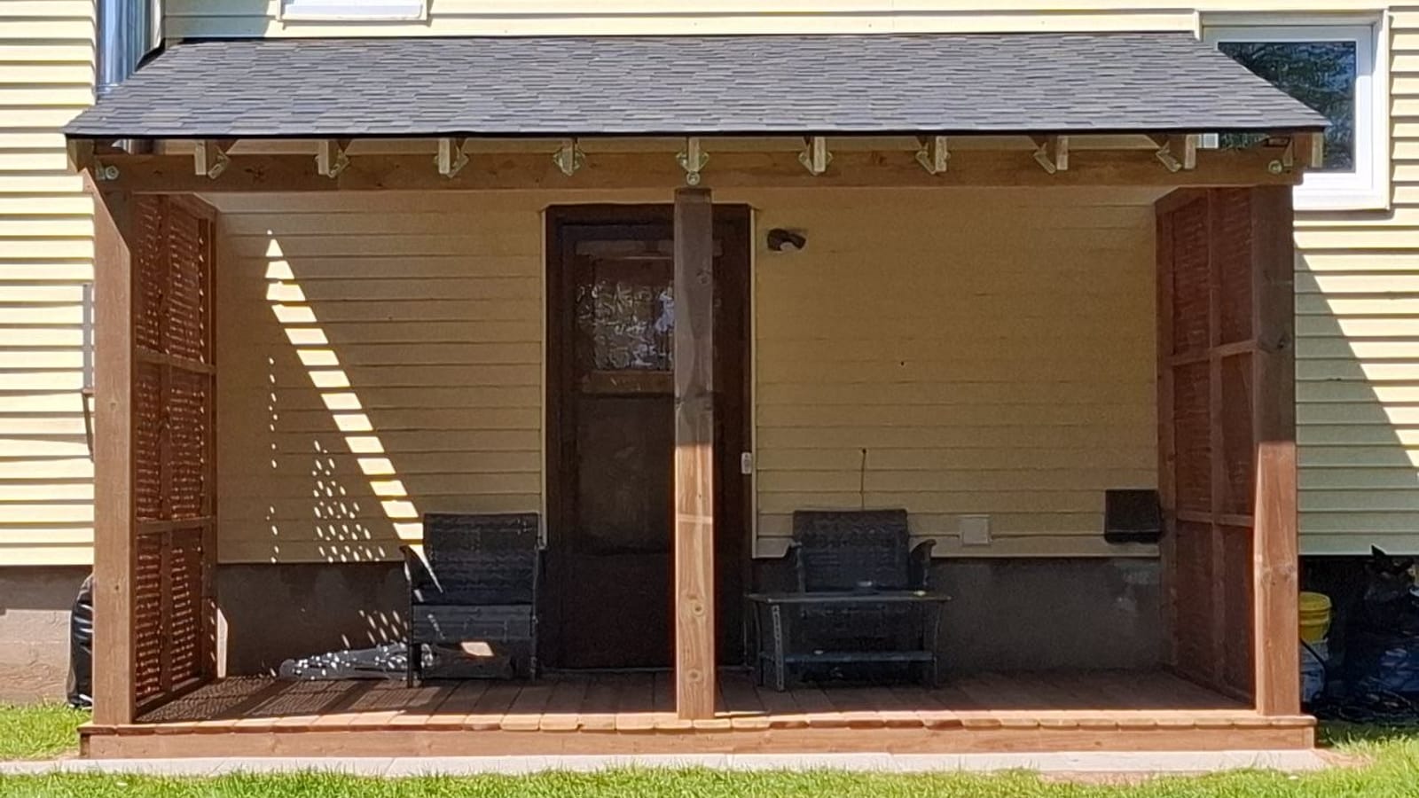 Rebuilt covered back deck at a Niagara Falls home, with wood posts, lattice side panels, and a shingled roof