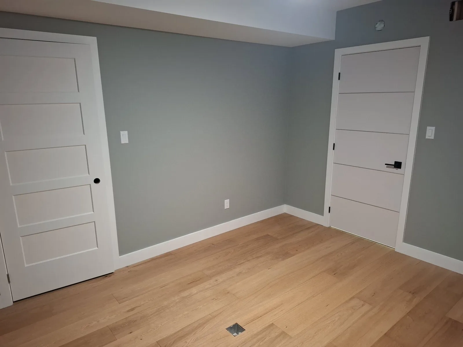 Finished office with grey walls, white doors, and new wood flooring