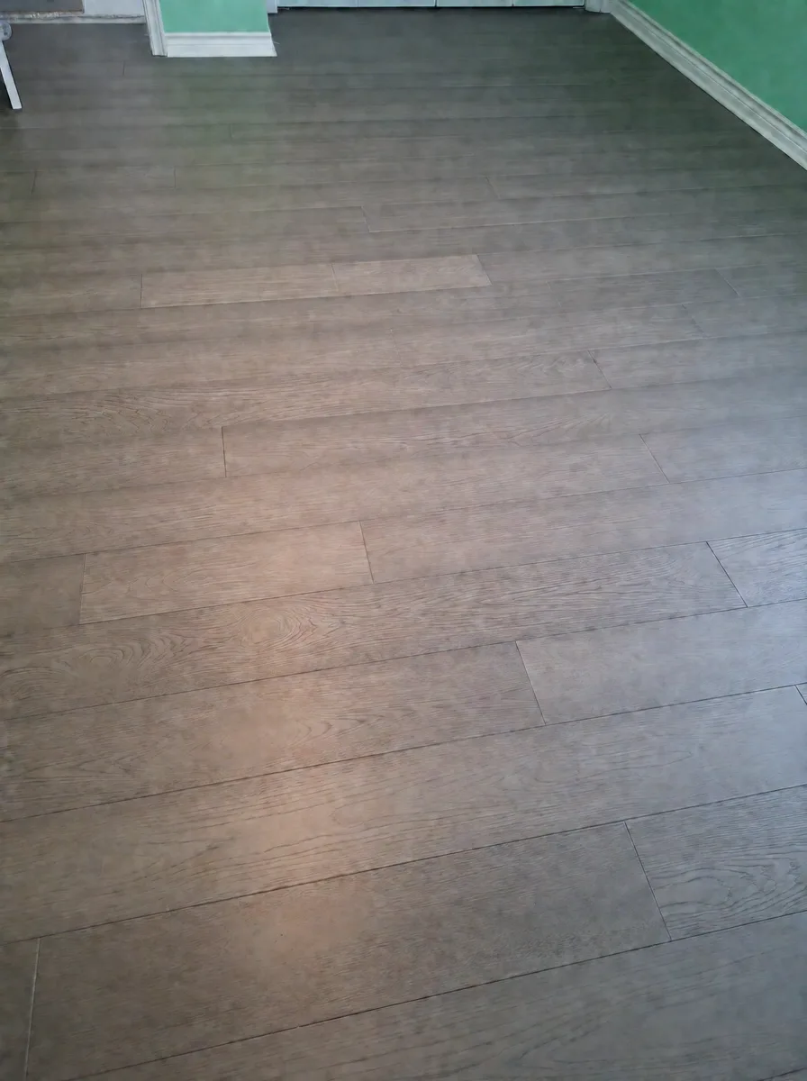 Grey-brown oak planks across a bedroom floor with white baseboard