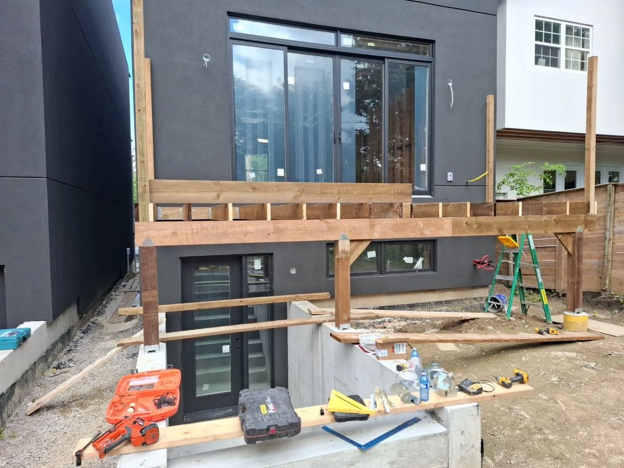 Modern Toronto townhome deck build with natural wood decking and railing — deck framing posts and beam